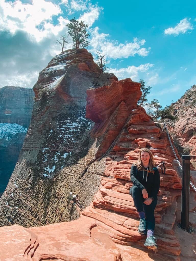 A hiker rests next to the chains on Angel's Landing 
