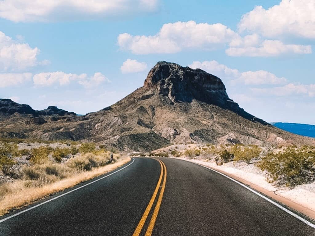 a blacktop highway leads into the mountains on Ross Maxwell Scenic Drive in Big Bend National Park