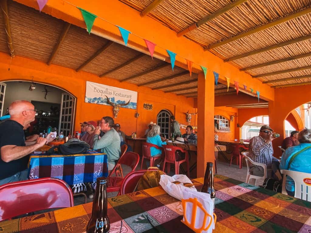a colorful orange painted patio with mexican decor at Boquillas Restaurant where tourists drink beer and eat mexican food
