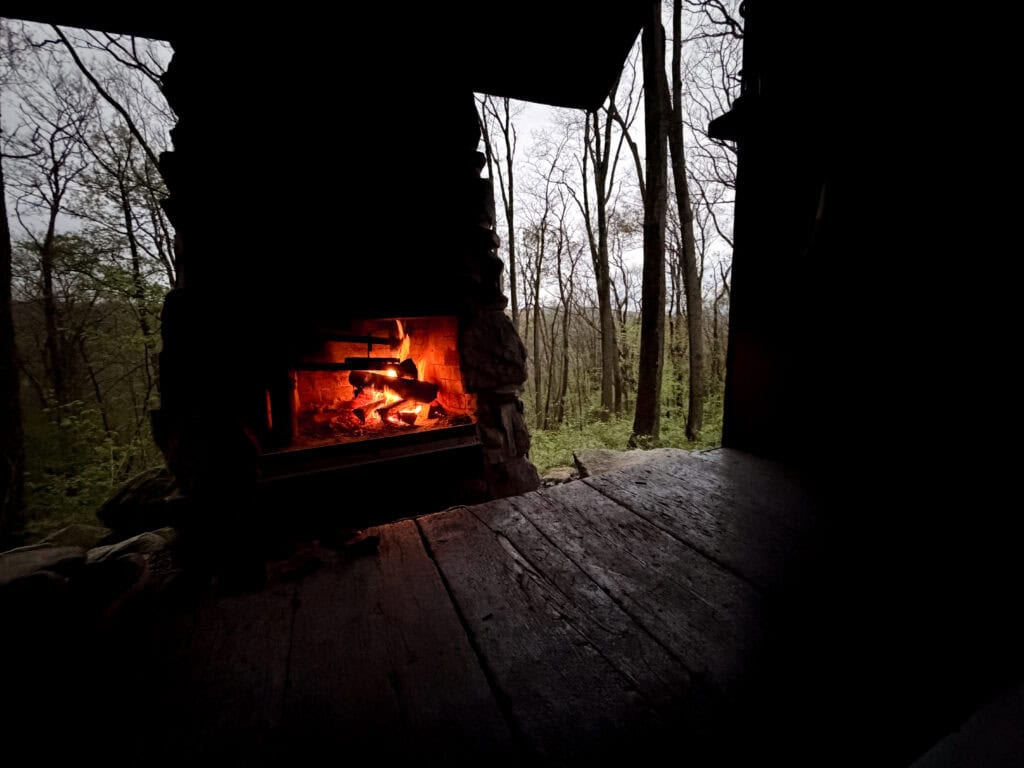 a cozy fireplace at night at the Route 30 Shelter Area on the LHHT
